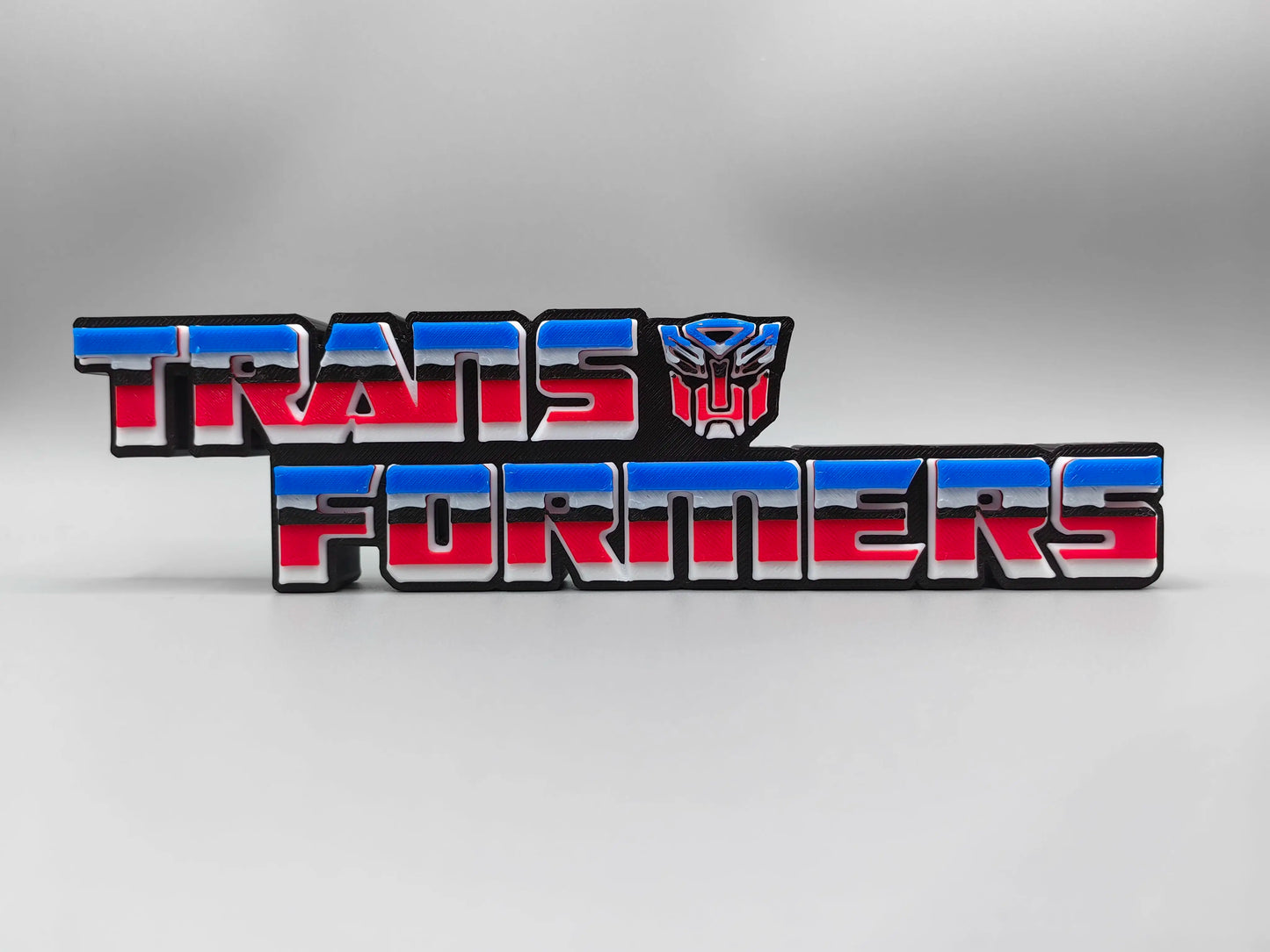 Transformers-plaat met rood en blauw Autobot-logo — driedimensionale bureauversiering