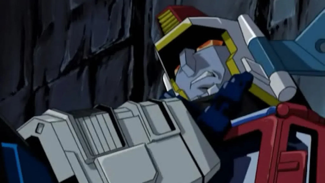 Robot gris et rouge en posture de combat devant un mur sombre, style animé – Transformers.