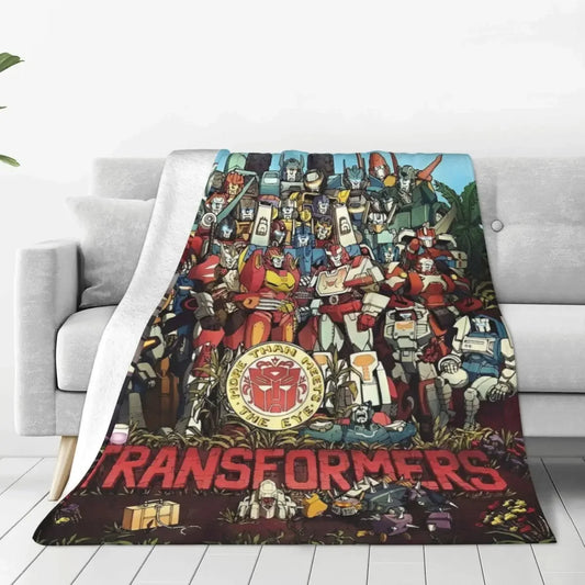 Plaid imprimé Transformers, groupe de robots colorés en pose héroïque sur canapé blanc – Transformers.