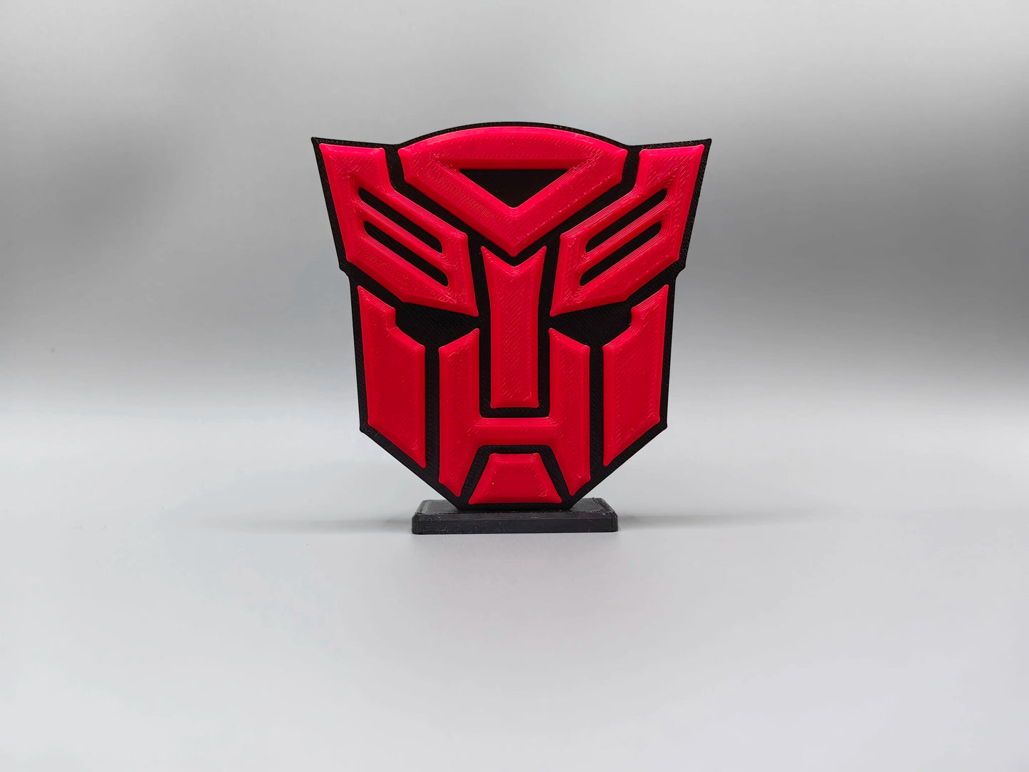 Transformers-plaat met intensrood Autobot-logo — Massieve schilddecoratie voor op het bureau